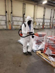 Worker doing disinfectant fogging cleaning at a workplace
