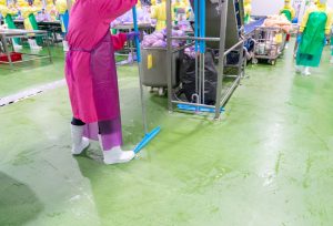 Janitorial employees cleaning a manufacturing plant