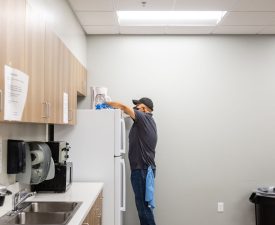 5 Star Janitorial employee wipes down a fridge